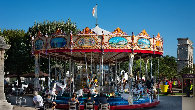 Tiovivo antiguo de colores en una plaza arbolada con familias sentadas alrededor