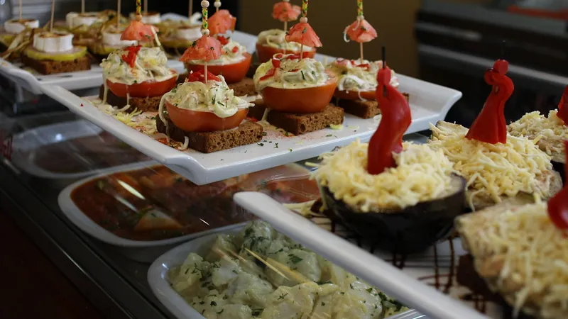 Barra de un bar con bandejas de tapas y pinchos variados