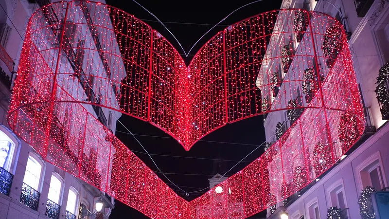 Arcos de luces navideñas rojas sobre una calle comercial del centro de Madrid