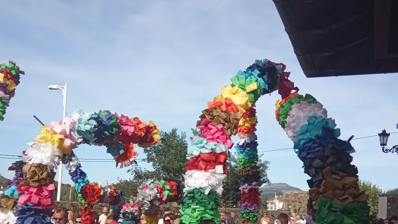 Arcos de flores de papel de colores de los danzantes en la fiesta de un pueblo de Cantabria