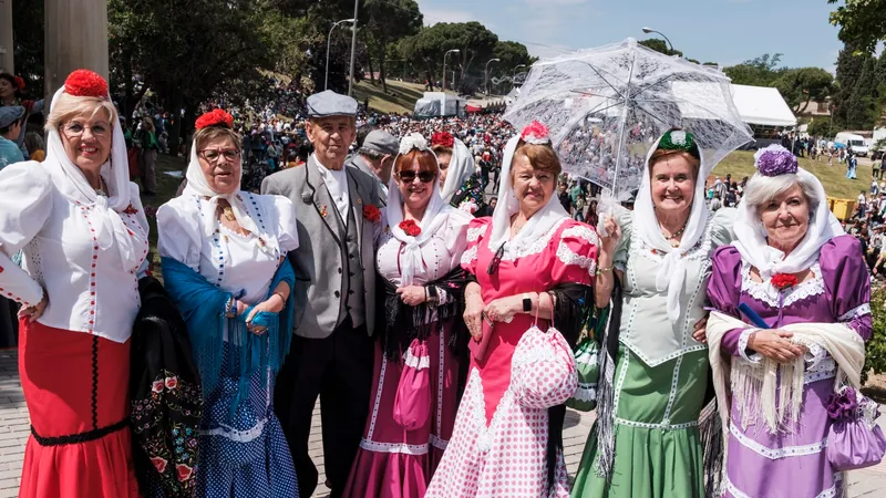 Grupo de chulapas con mantones y claveles celebrando San Isidro en la pradera de Madrid